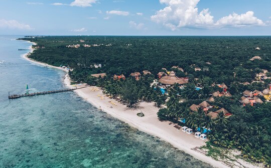 un grupo de personas en una playa cerca de un cuerpo de agua