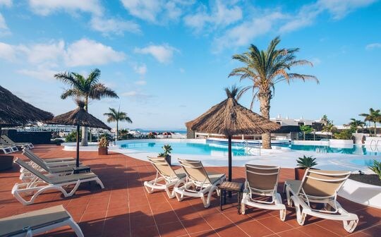 un grupo de sillas de jardín sentado en la parte superior de una playa de arena