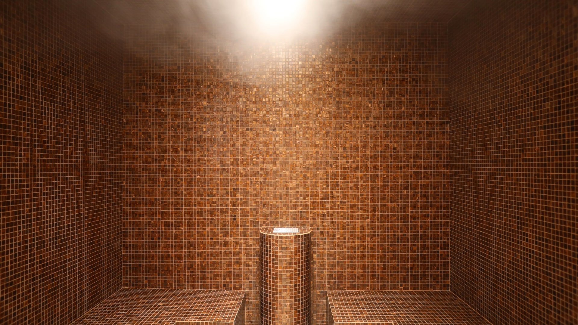 uma banheira branca sentada ao lado de uma parede de azulejos