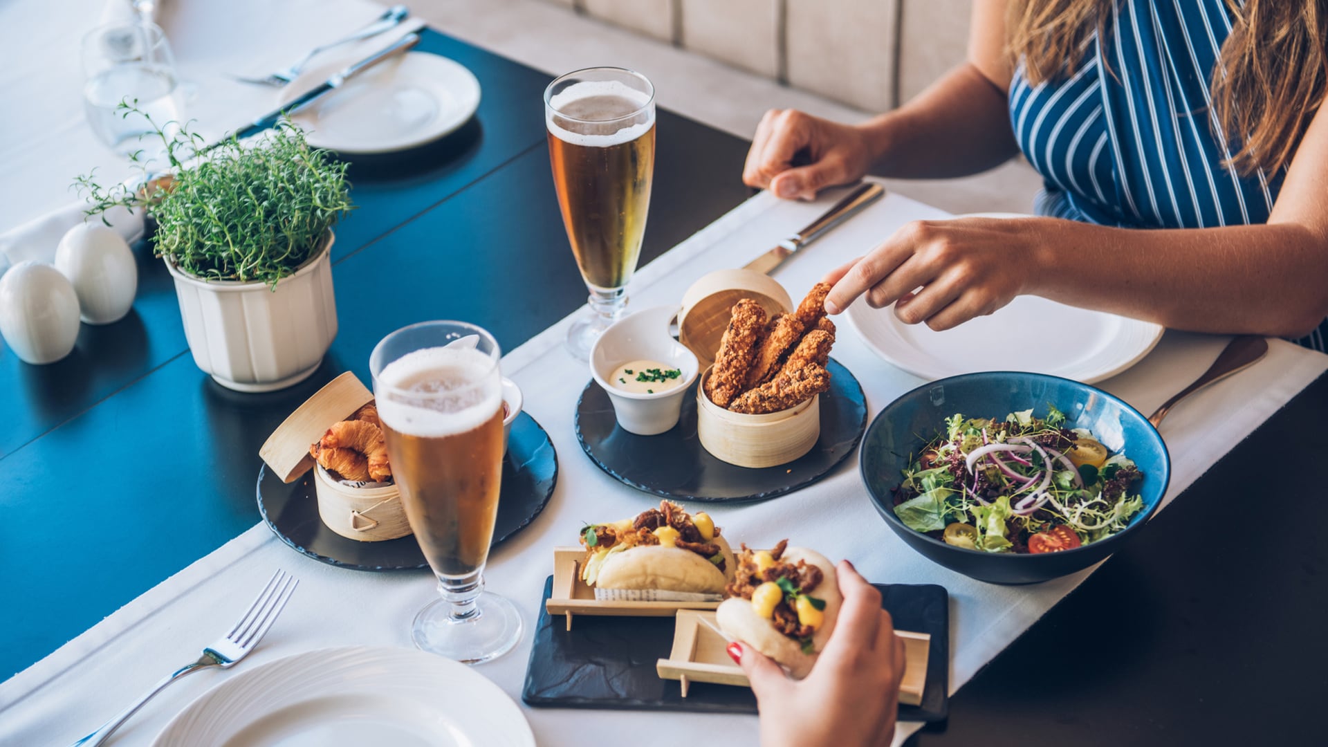 uma mulher sentada em uma mesa com um prato de comida