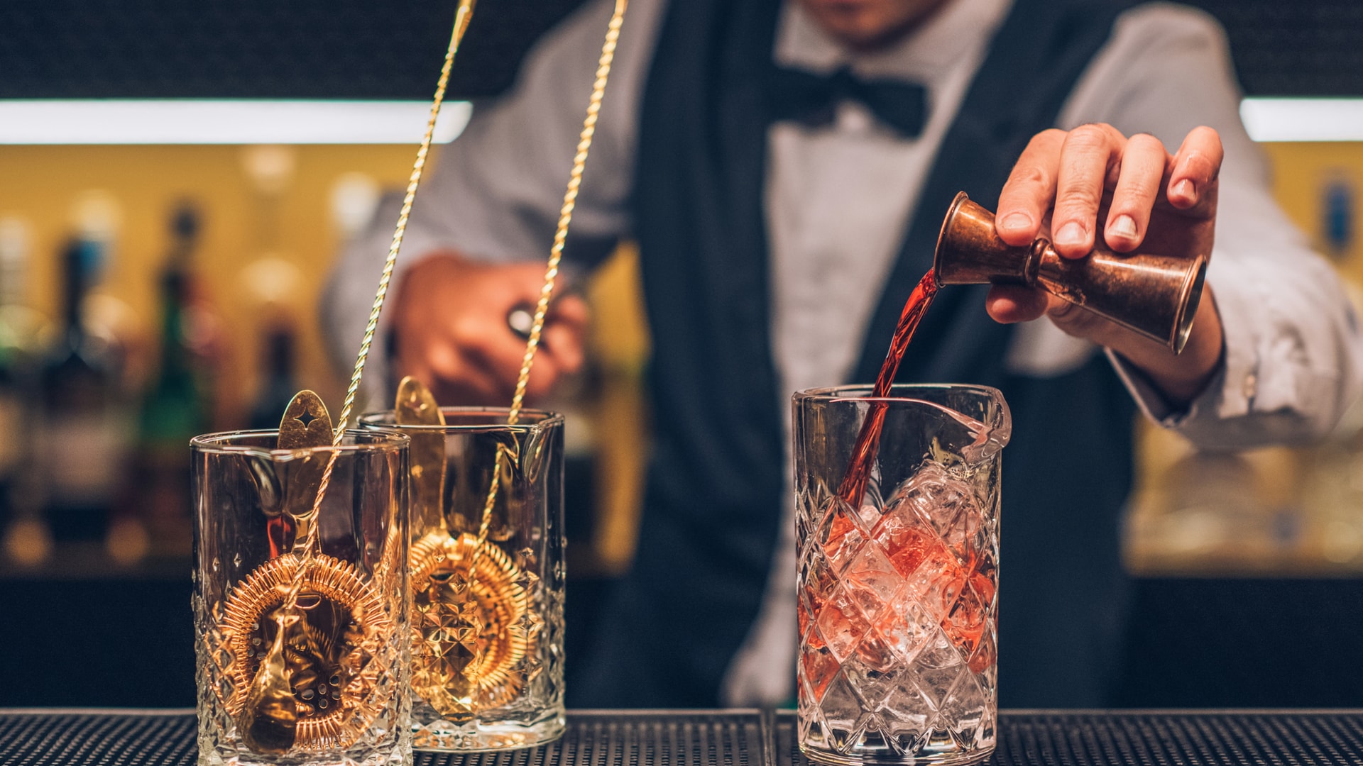 uma pessoa sentada em uma mesa com taças de vinho